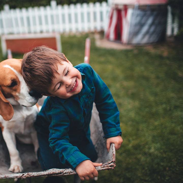 Ein Junge mit Hund im Garten